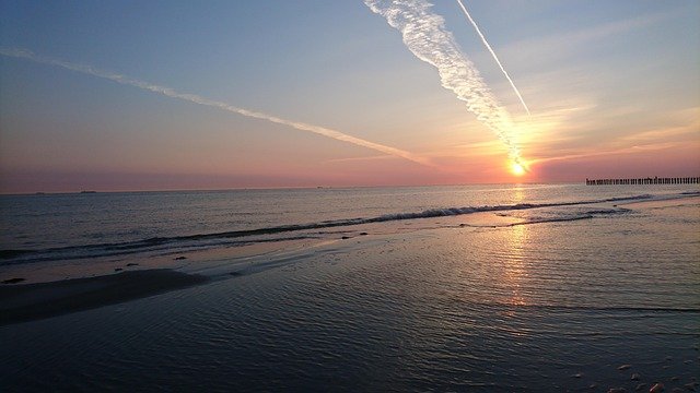prachtige zonsondergang boven zee met strand en wolkenformaties