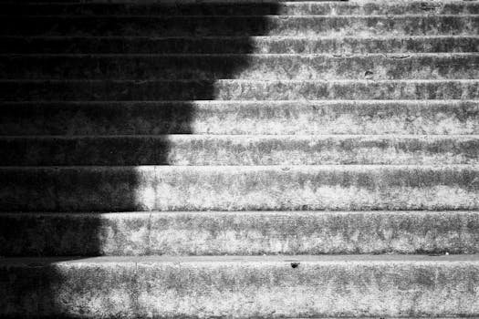 Artistic monochrome view of shadowed stone steps with dramatic lighting.
